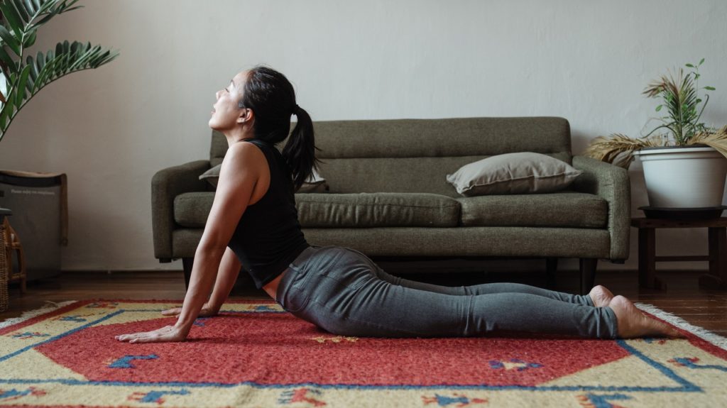 young girl making yoga position cobra